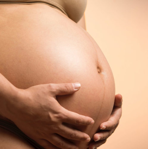 pregnant belly with hand cupping the bottom