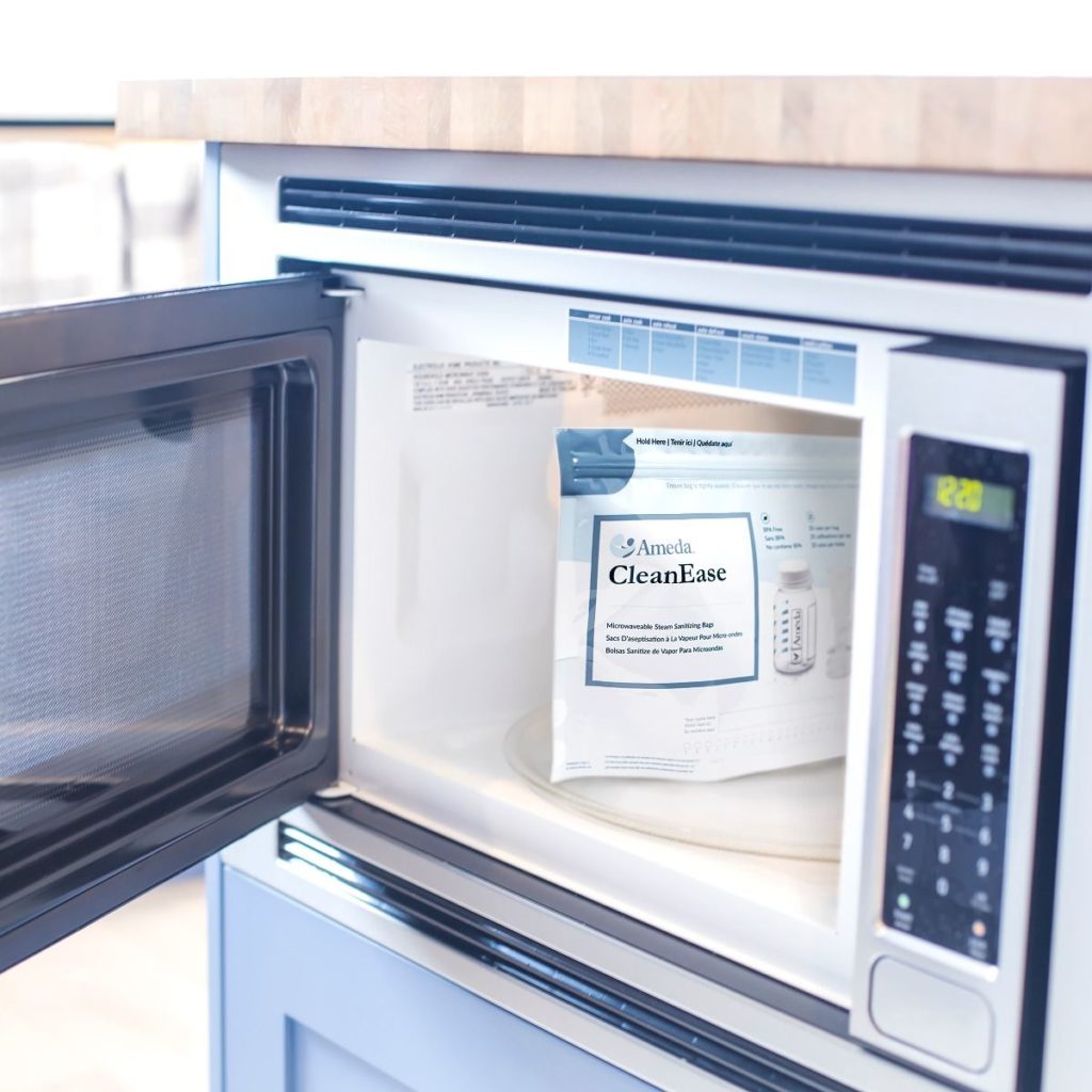 An "Ameda CleanEase Steam Bags" microwavable steam bag sits inside an open microwave on a kitchen worktop, displaying cleaning instructions and product details.